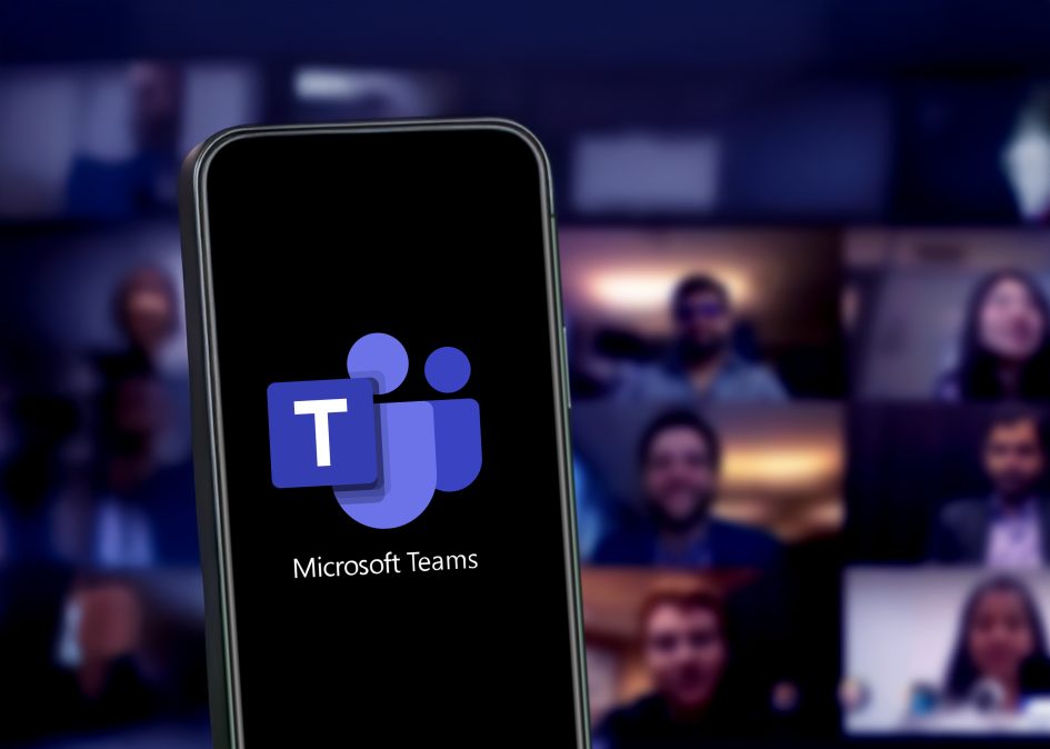 Microsoft Teams on a smartphone screen, with a blurred background of a virtual meeting in progress. As an IT Managed Service Provider (MSP), we help businesses unlock the full potential of Microsoft Teams, streamlining communication, enhancing collaboration, and ensuring seamless integration with your IT environment